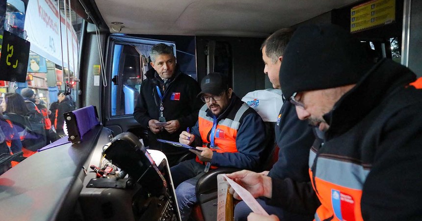 Tres fiscalizadores de la Dirección del Trabajo verifican la jornada de manejo de un chofer de bus interprovincial.