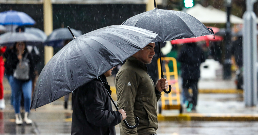 Personas caminan bajo la lluvia protegidos con sus paraguas