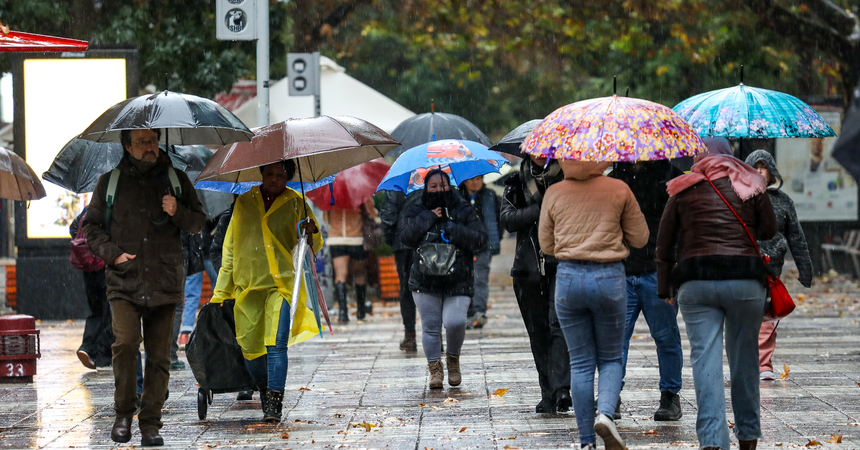 Personas caminan bajo la lluvia protegidos con sus paraguas