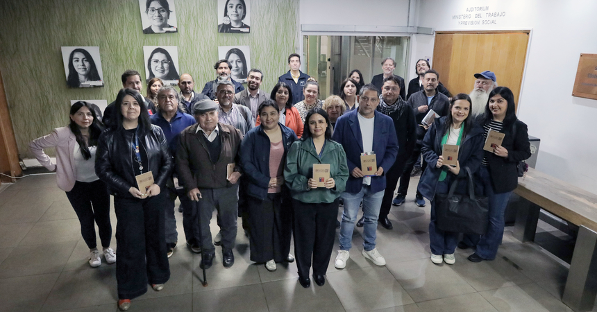 Un grupo de hombres y mujeres asistentes a la charla sobre mipymes posan de pie a la salida del auditorio del Ministerio del Trabajo y Previsión Social